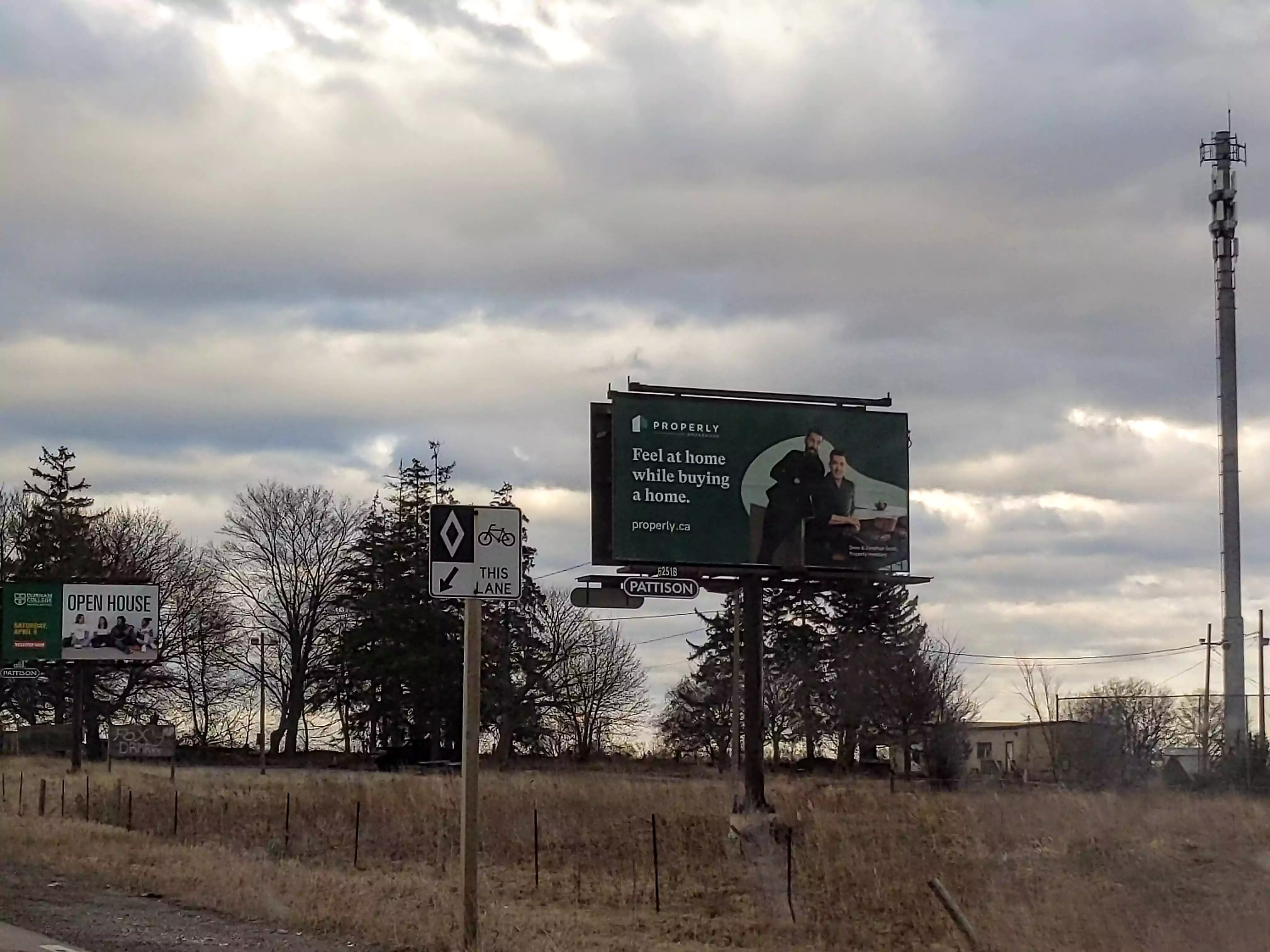 Roadside billboard for Properly, with the Scott Brothers and the text 'Feel at home while buying a home' and the url properly.ca
